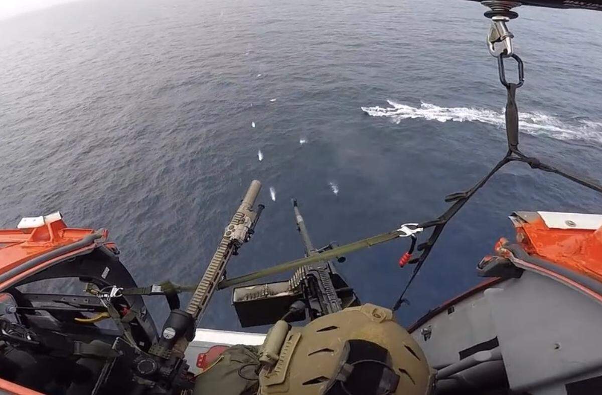 A U.S. Coast Guard helicopter door gunner fires a volley of machine-gun bullets in front of the bow of a suspected cocaine-smuggling vessel off Colombia on Friday, May 8, 2026.
